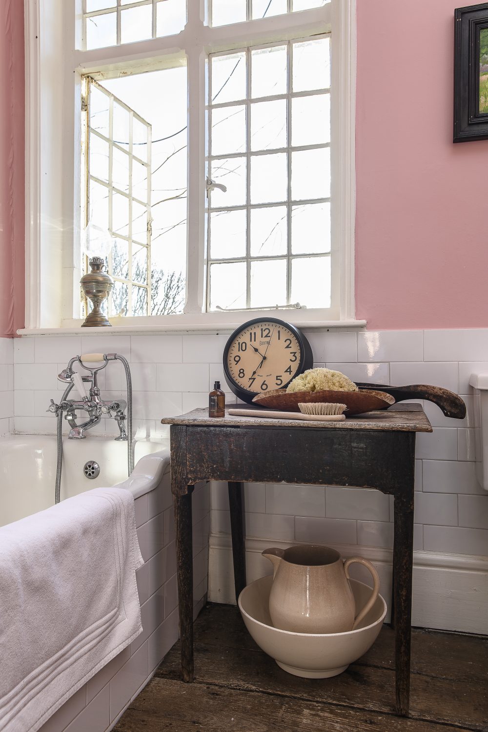 The pink family bathroom has the original wide floorboards. “I love the way that you can see how they were sawn by hand – made in a saw pit,” Alex explains