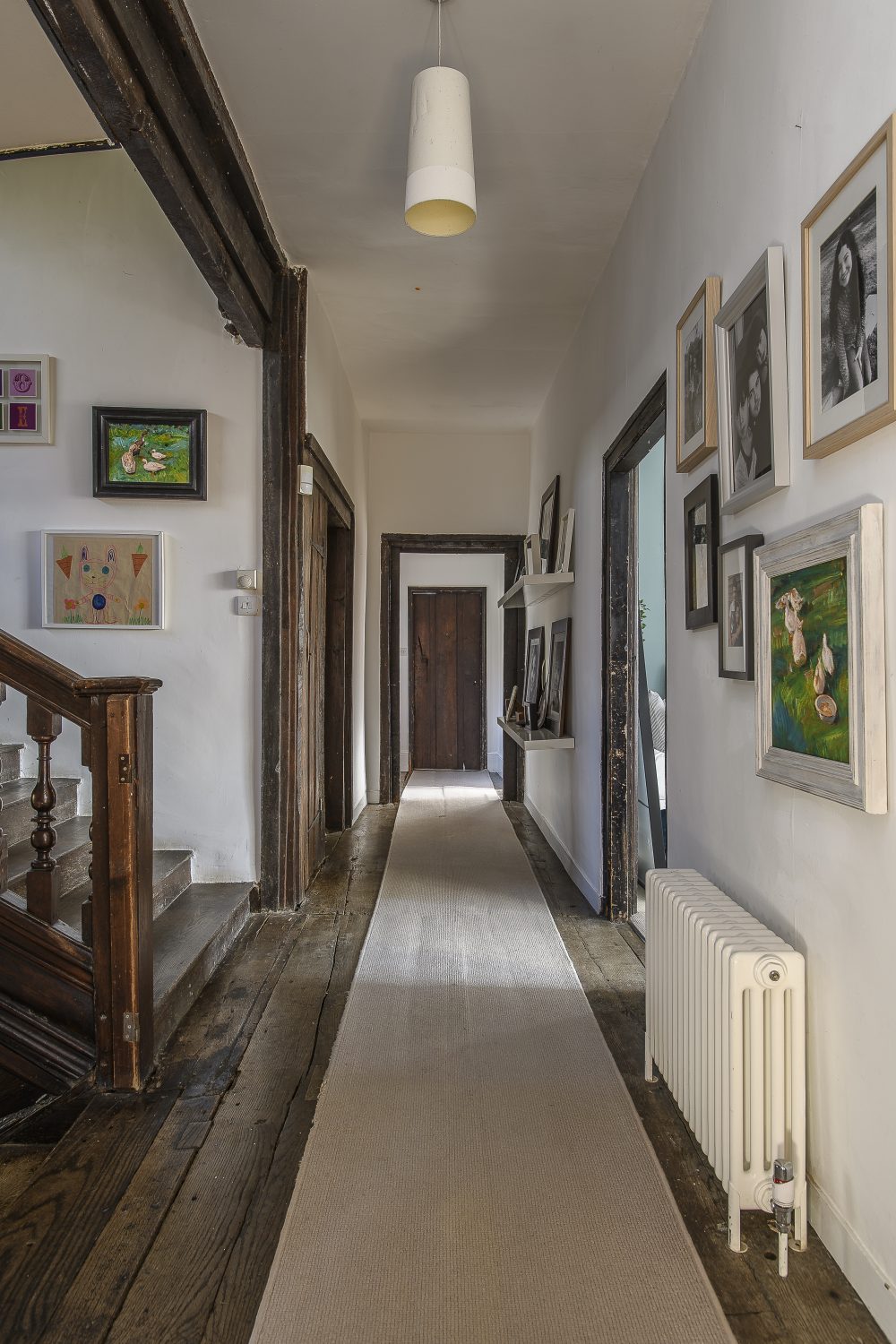 On the first floor, several large bedrooms and a family bathroom are accessed via a long corridor