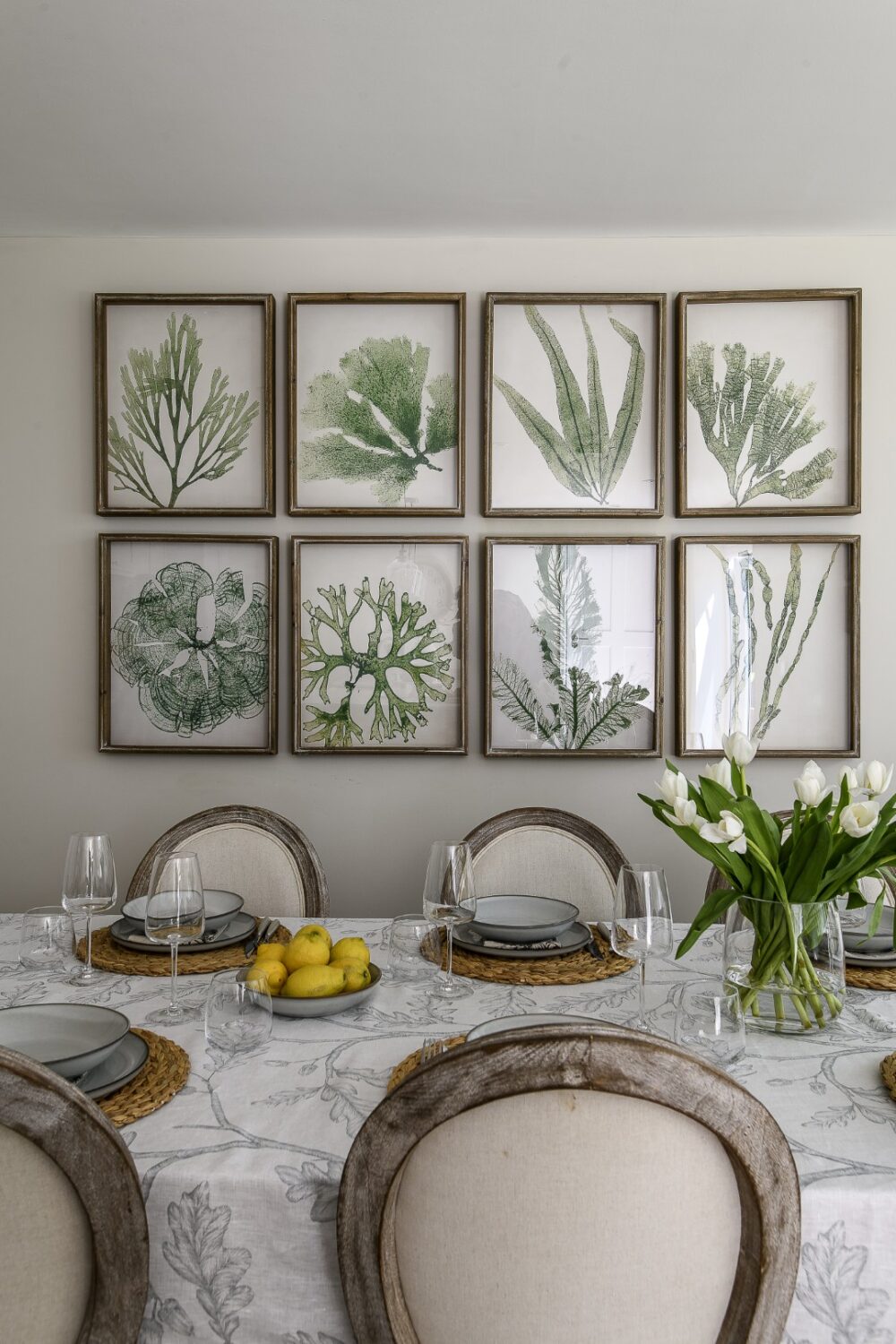 A set of eight coral and seaweed prints span the wall above the kitchen table creating a focal point and adding definition to the dining area.