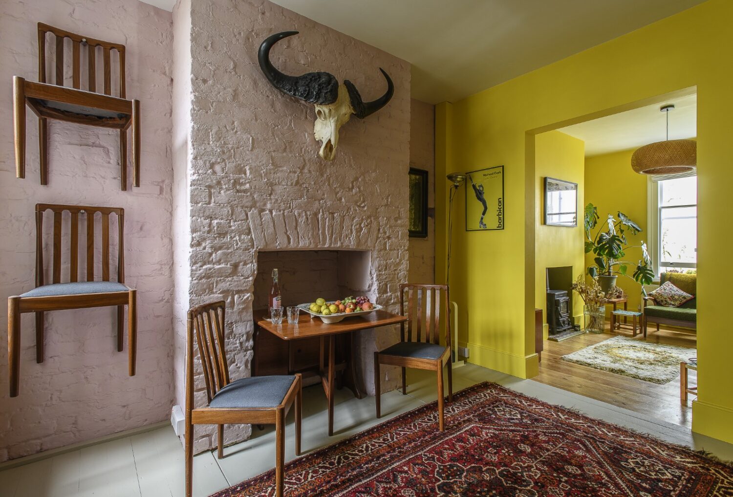 Midmod chairs, from Funkin Junk interiors, hang on pegs – designed by Antony Gormley for the Homebase × Tate millennium project – when not in use. A large rug conceals the entrance to the cellar below