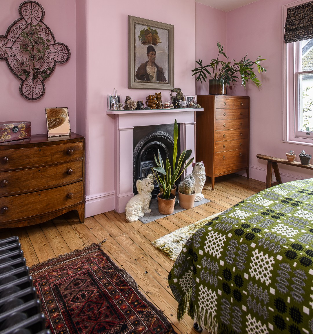 A beaded coffin topper is mounted to one side of the fireplace, and the mantelpiece is filled with more curios