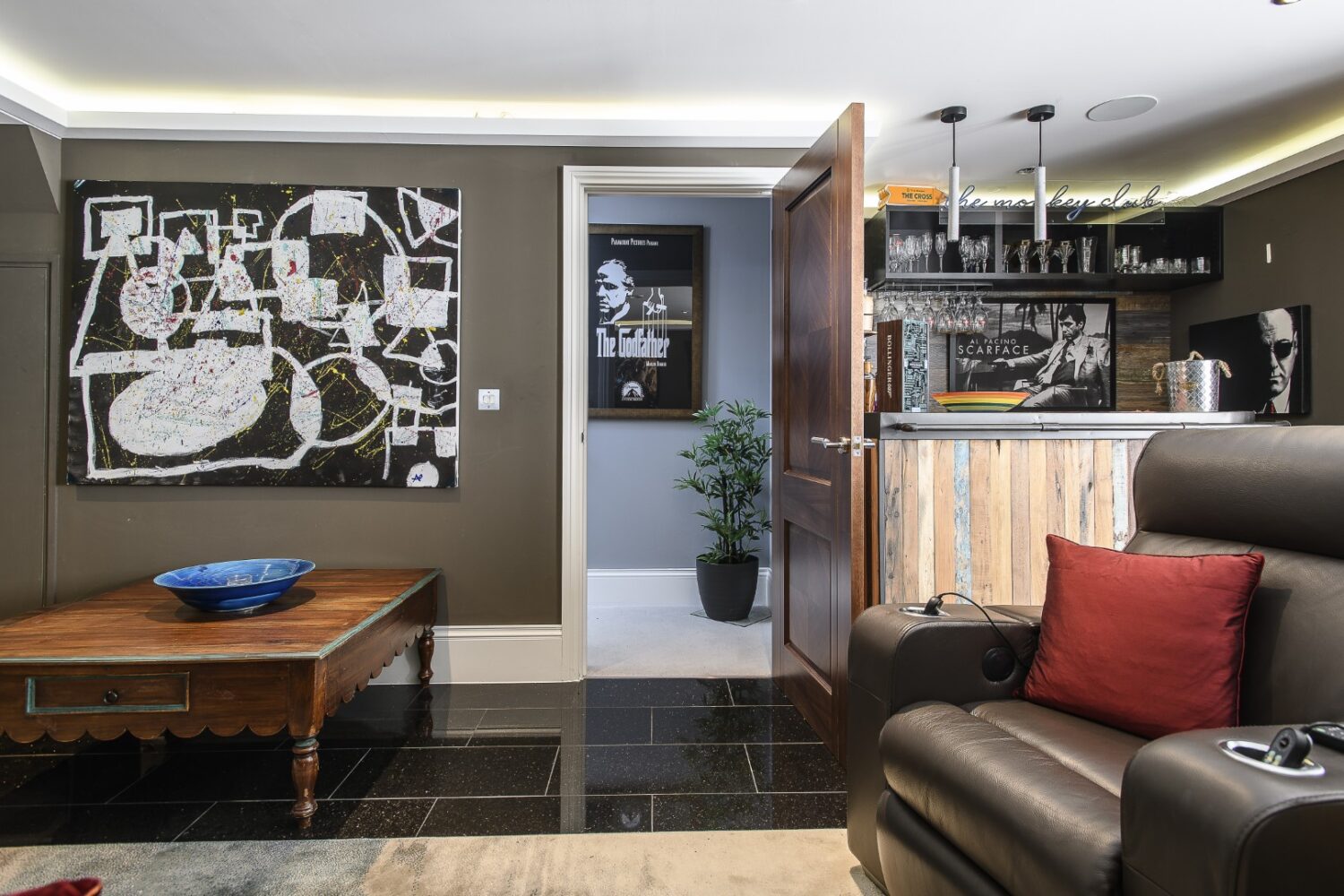 the cinema room is a family magnet: leather recliners line one side, a beanbag sprawls across the floor and a wall of classic film posters sets the tone.