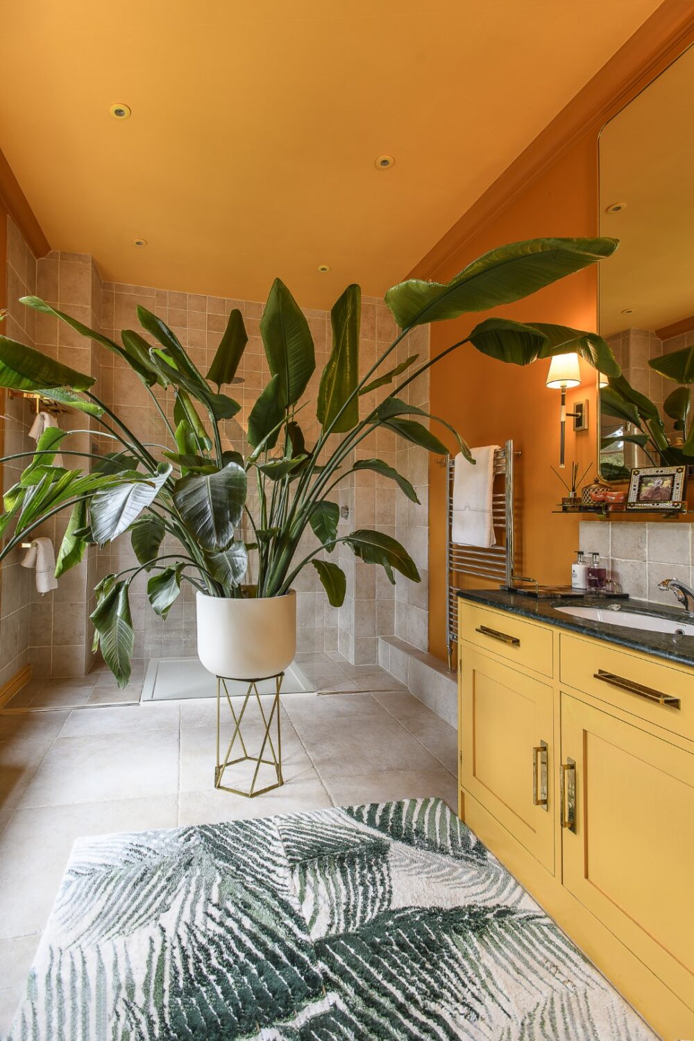 En suite bathroom painted in vivid orange and mustard, its design inspired by David Hockney’s famous LA pool paintings