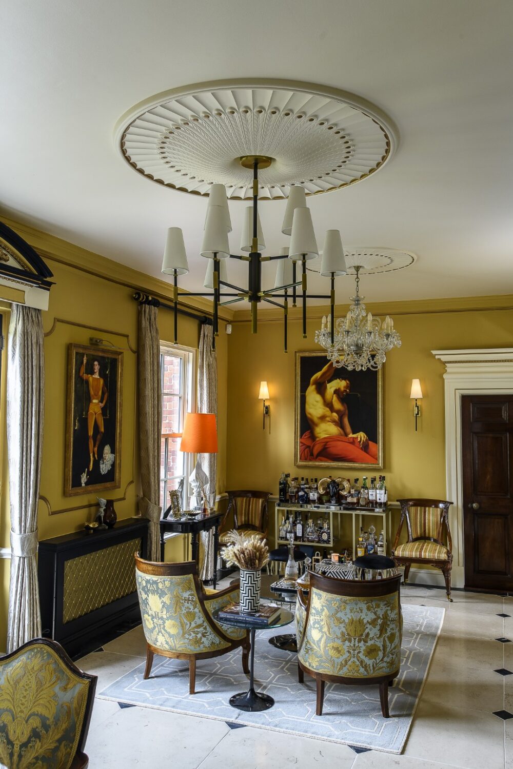 He used a rich yellow ochre colour on the walls and added black and gold furniture and gilded panelling, dado rails and vintage chandeliers