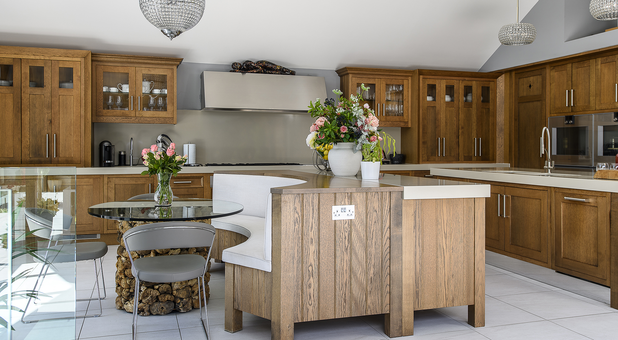 In the kitchen twin islands stretch out under glittering pendant lights, worktops provide plenty of space for cooking and huge windows connect directly to the terrace outside.