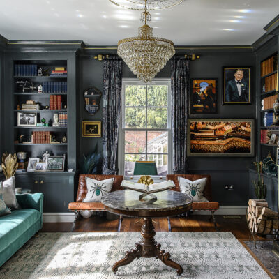 The library is an evening room dressed in rich blue gloss paint, inspired by 1920s Art Deco nightclubs and speakeasy bars of Paris and New York. Antique chandeliers sourced from a dealer in Turkey hang above the rug from The Rug Company, while Sean’s own paintings line the walls alongside works by local artists