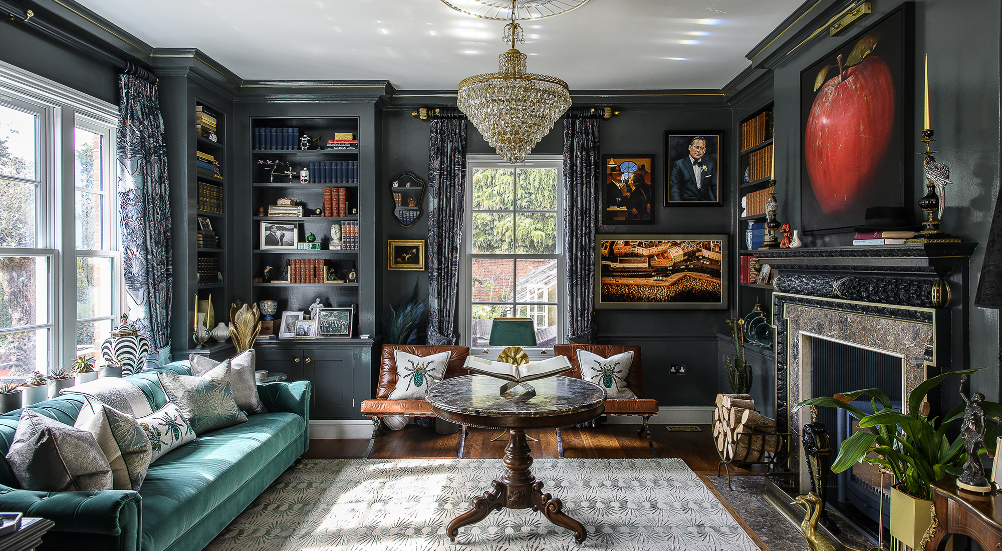 The library is an evening room dressed in rich blue gloss paint, inspired by 1920s Art Deco nightclubs and speakeasy bars of Paris and New York. Antique chandeliers sourced from a dealer in Turkey hang above the rug from The Rug Company, while Sean’s own paintings line the walls alongside works by local artists