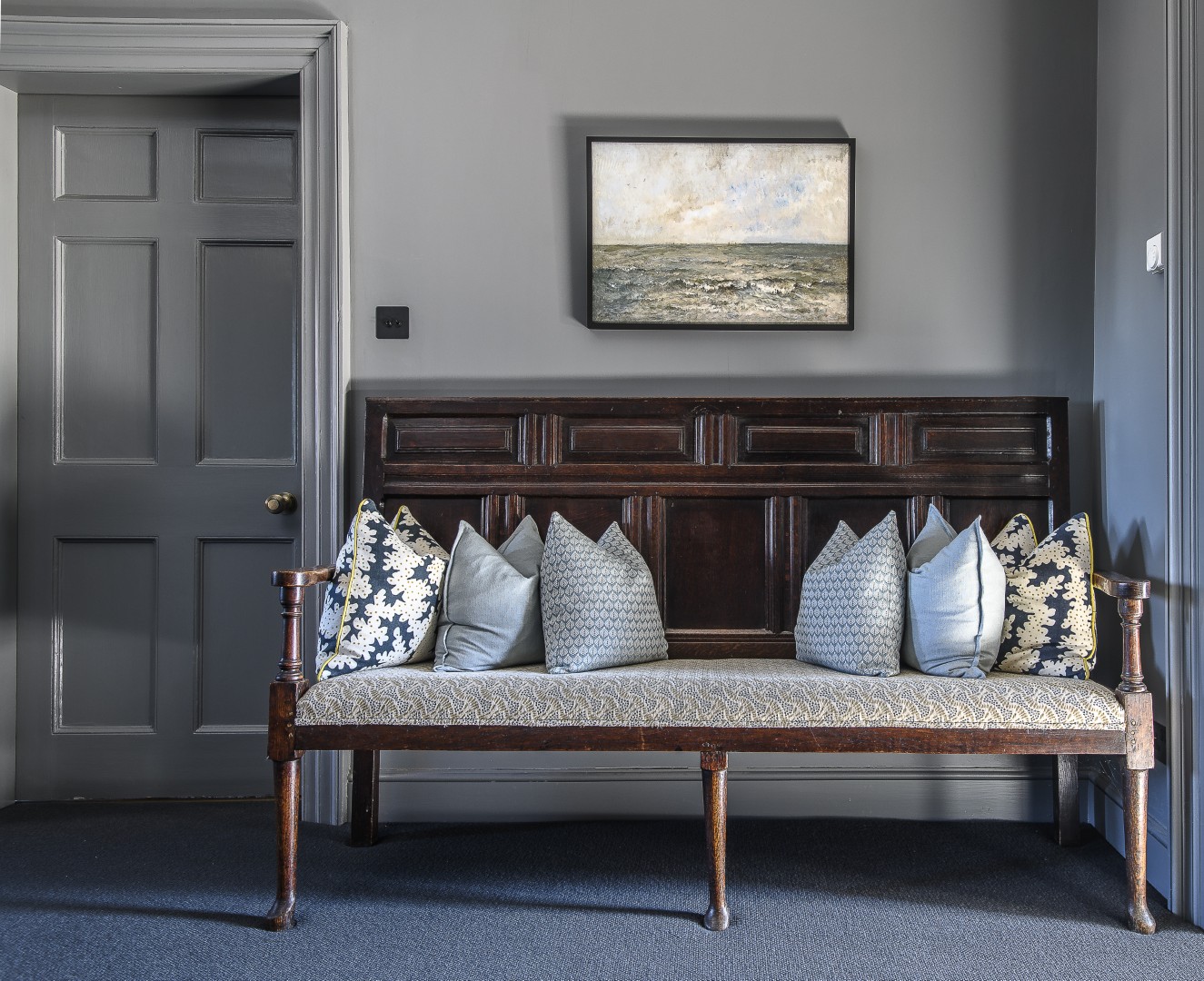The drawing room, in shades of deep grey and navy, spans across the back of the house on the first floor and is flooded with coastal light