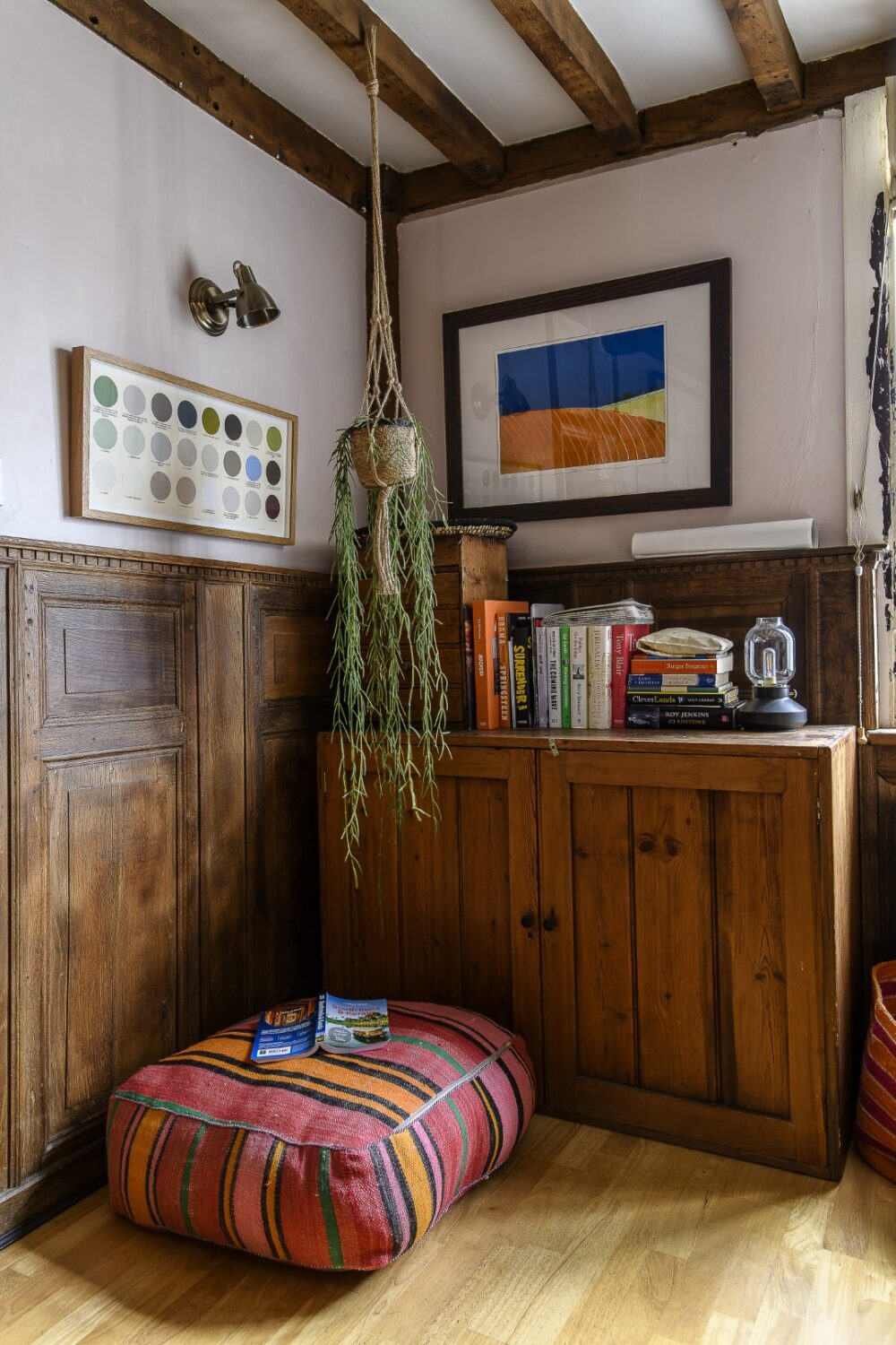 The panelled living room is home to a big inglenook fireplace, home to a ‘Be Kind’ print by Dandy