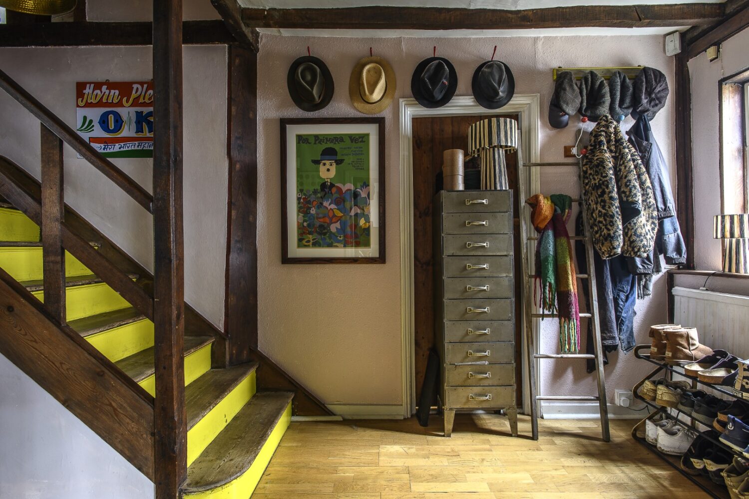 The staircase, a darker part of the house, is enlivened with limey-yellow treads