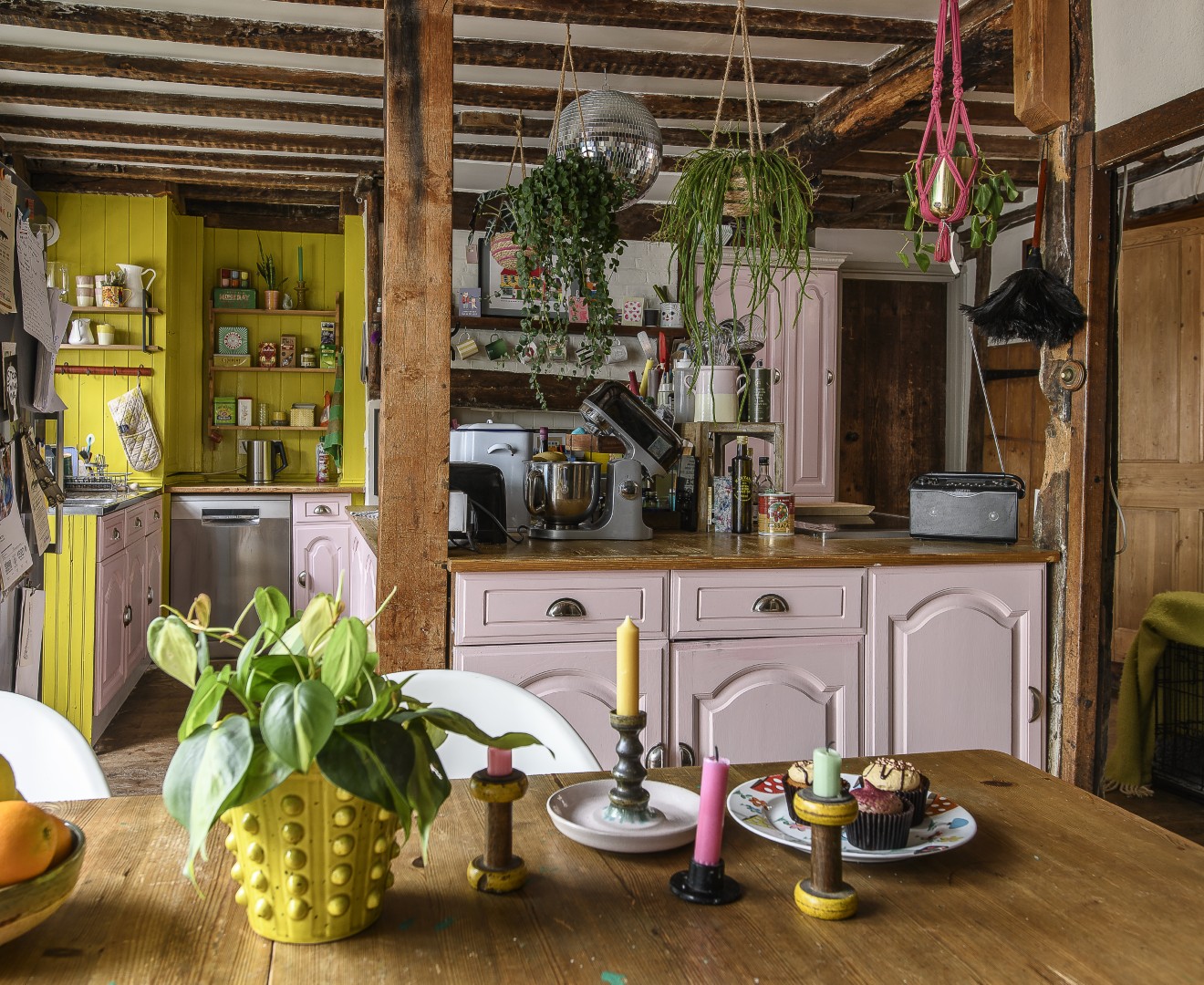 The kitchen is centred around a well-loved wooden island, filled with Kitchen Aid appliances, bottles of oils and jars of spices