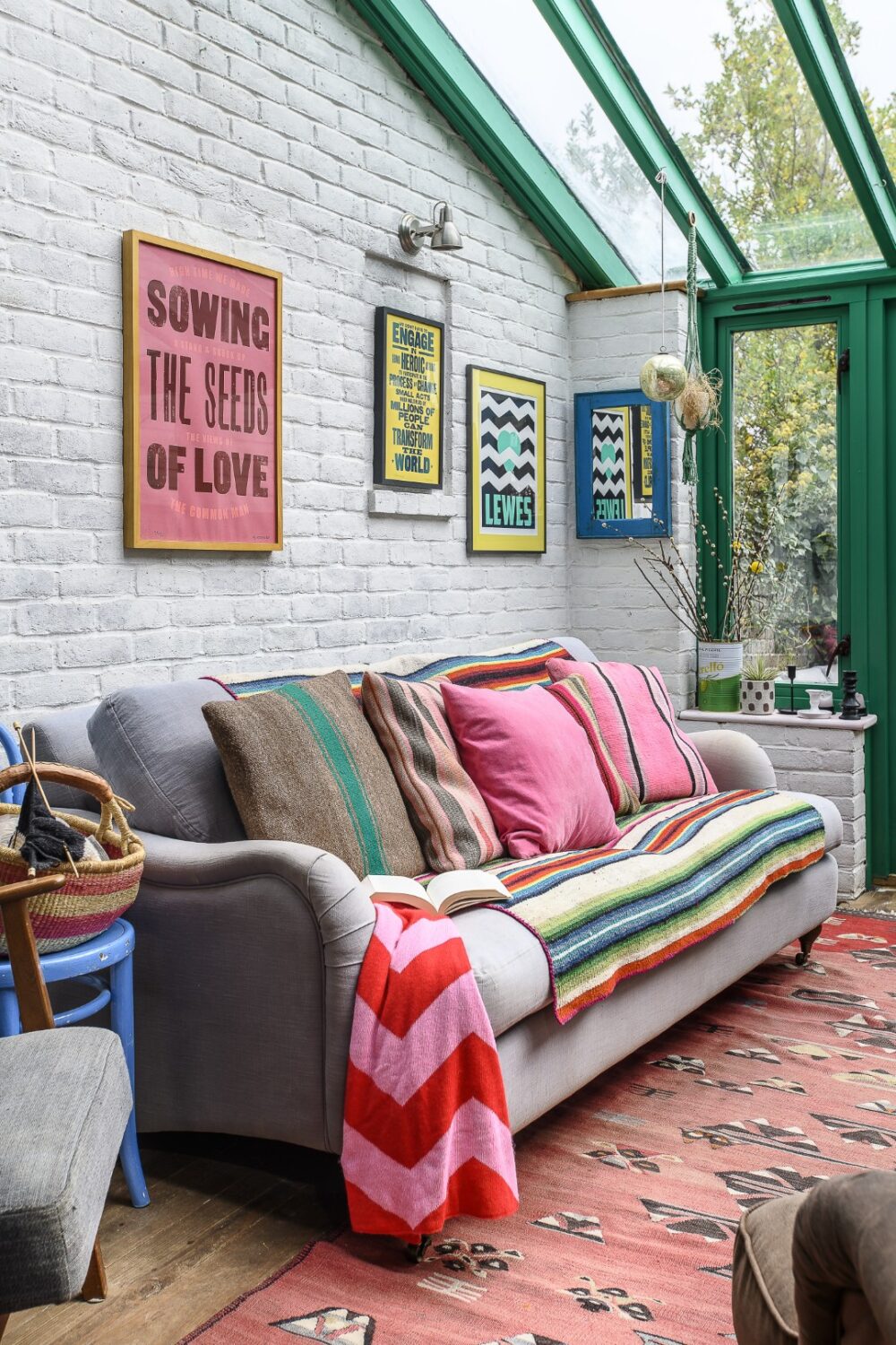 The conservatory is a later addition, which now floods the space with light. Framed prints on the wall are by the likes of Lucky Budgie Studio