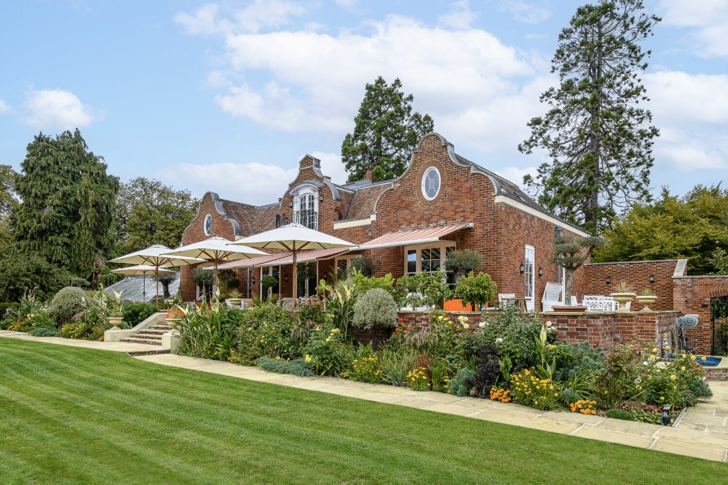 A border, planted in hot shades of red, yellow and orange, echoes the colourway on the terrace