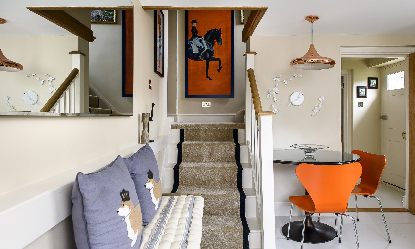 Pops of Sean’s signature orange and blue appear in the cottage’s kitchen-diner. The woman on horseback was transformed by Sean from a print to a painting, by covering it with gesso and working over it with a palette knife to give it the texture of a real painting