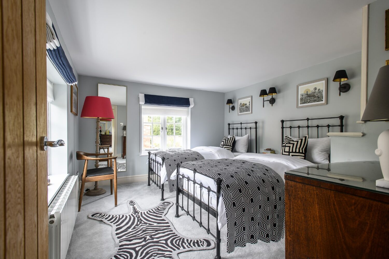 A guest room, which Sean has designed with twin beds and a whimsical faux-zebra print rug, is designed with children in mind: “It’s little whimsical, a little bit of fun,” Sean smiles