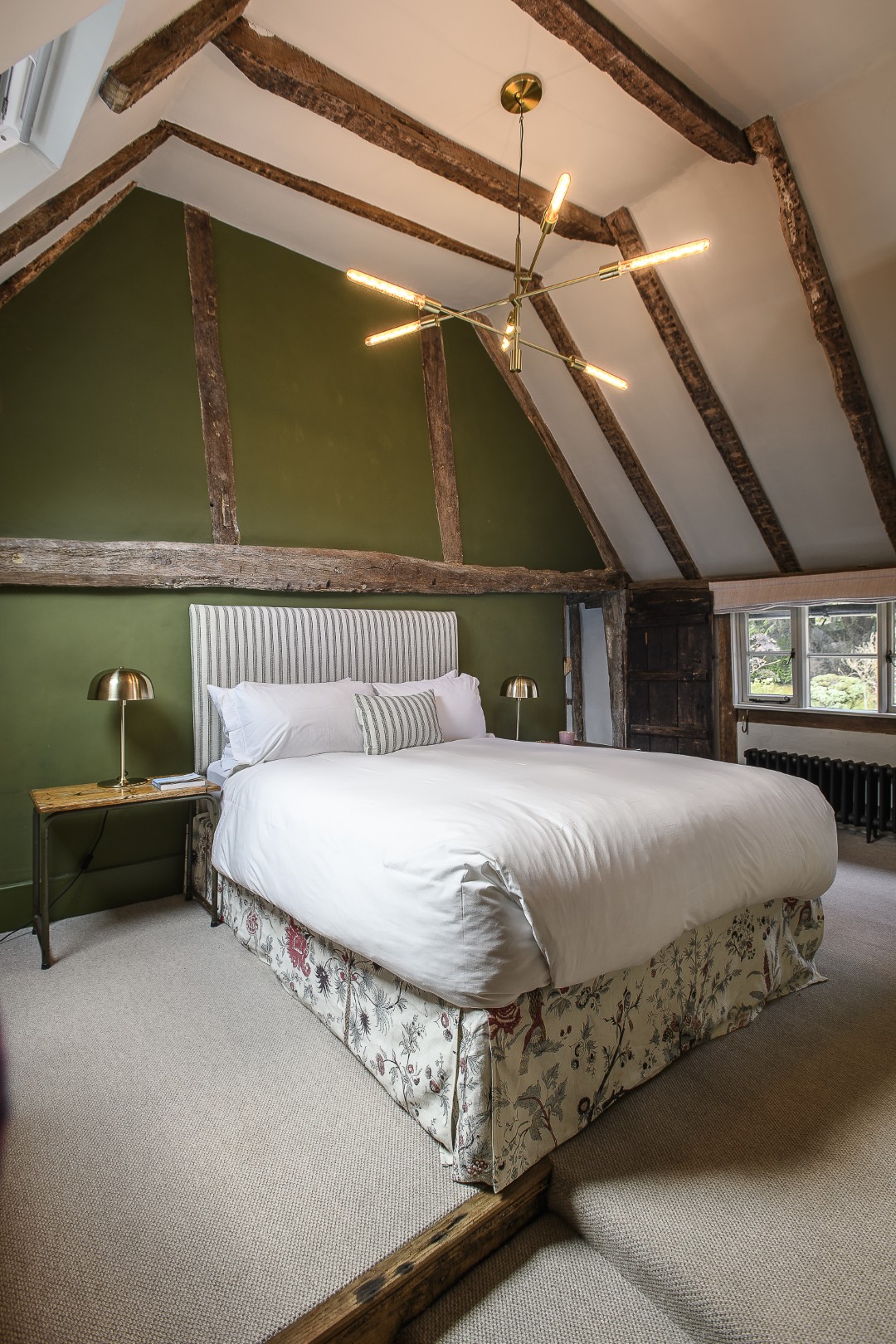 A Crittal-style sliding door leads neatly into an en suite. Throughout the house contemporary furnishings and lighting have been mixed with traditional to complement the charm of the building’s original features.