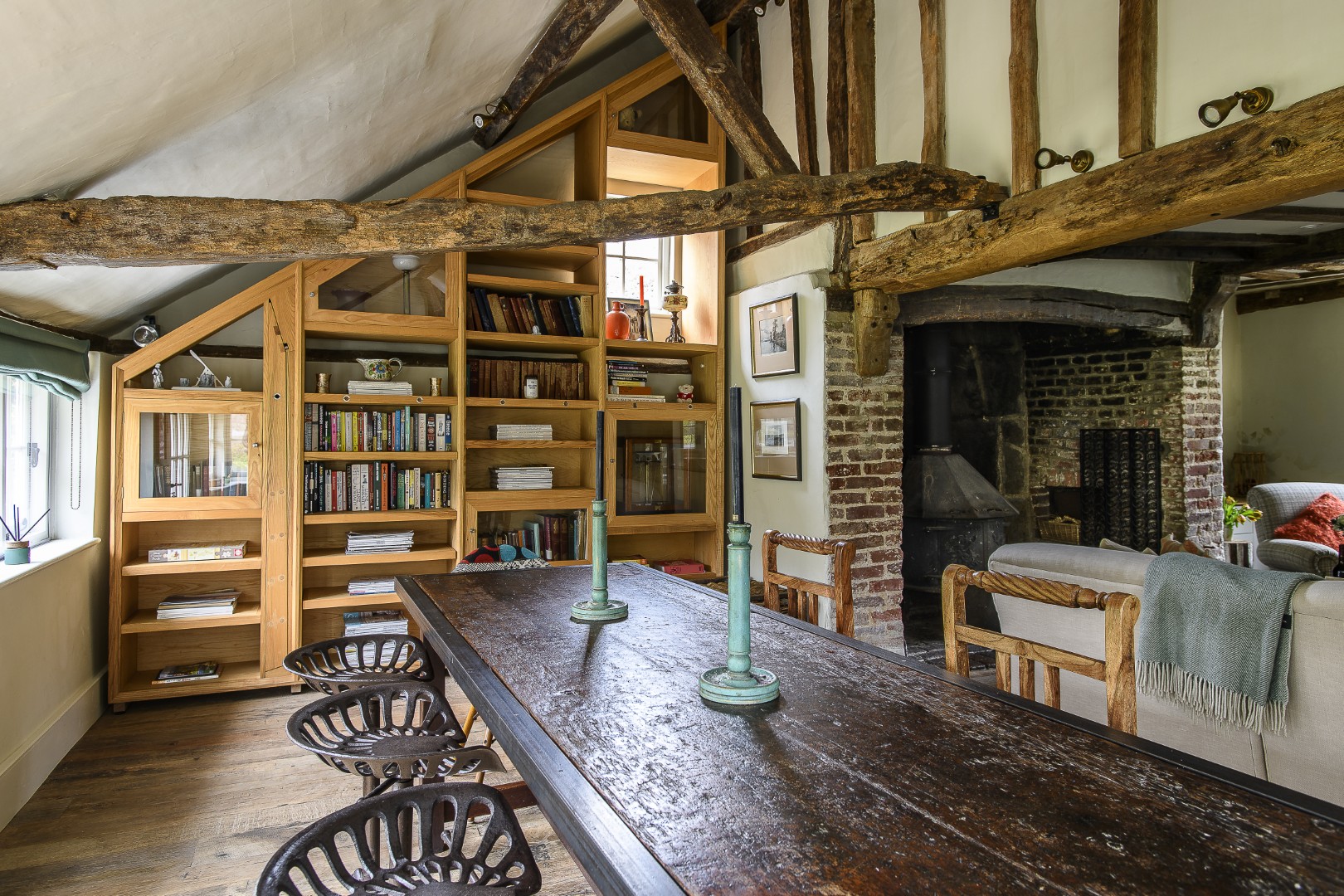An informal dining area is to one side of the drawing room. Books and curios relating to A. A. Milne are displayed in the custom-made book cases