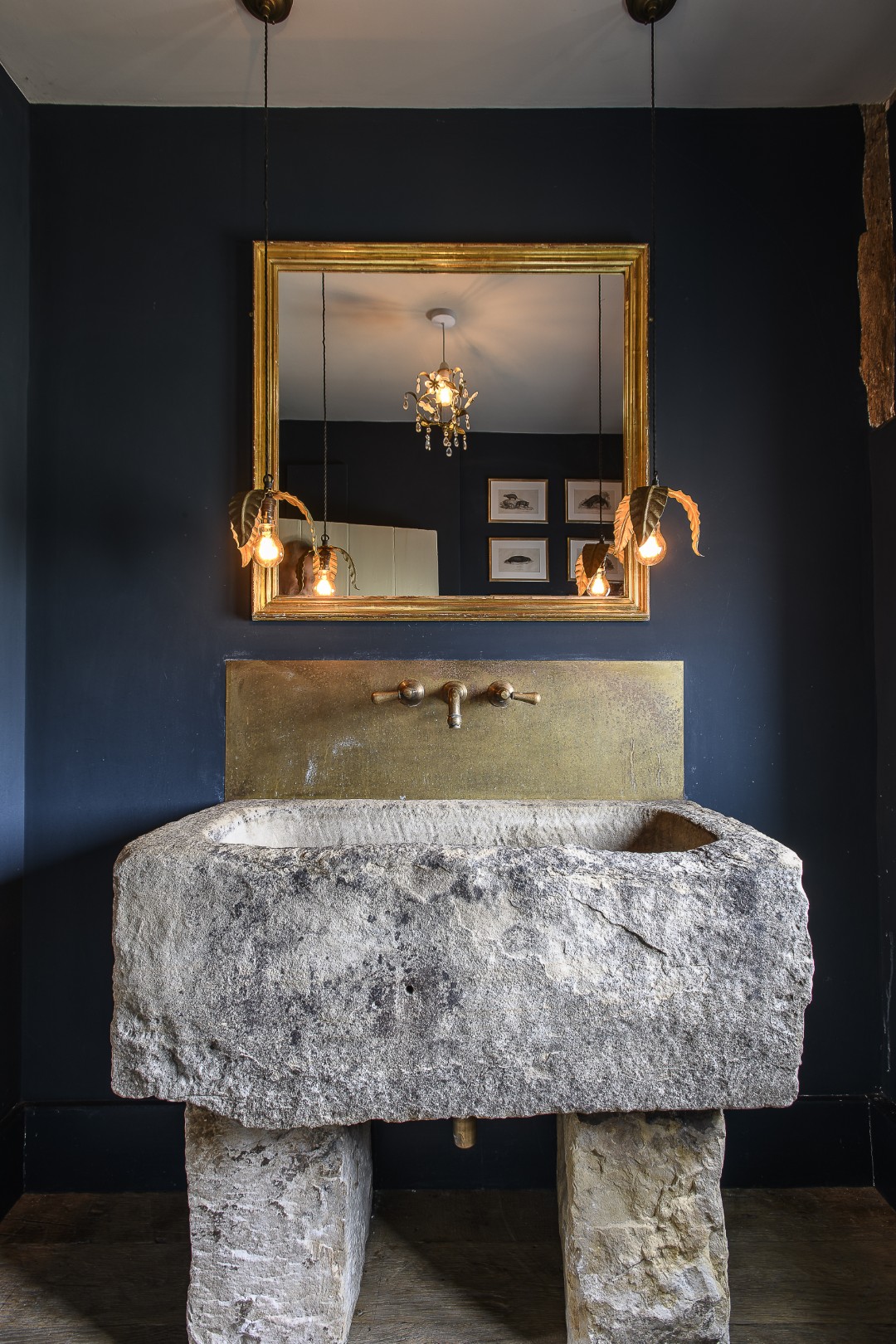 The downstairs loo, painted a deep navy is home to a sizeable stone basin.