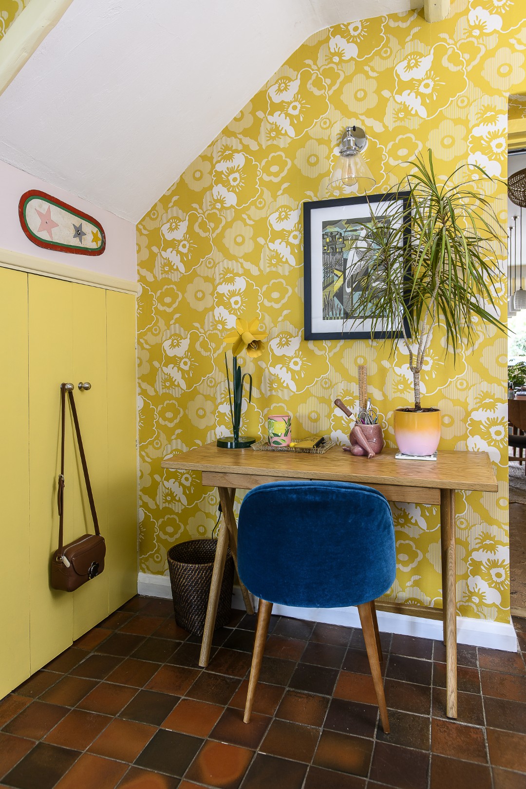 A daffodil table lamp by Bliss Home illuminates a workspace neatly tucked beneath the stairs.