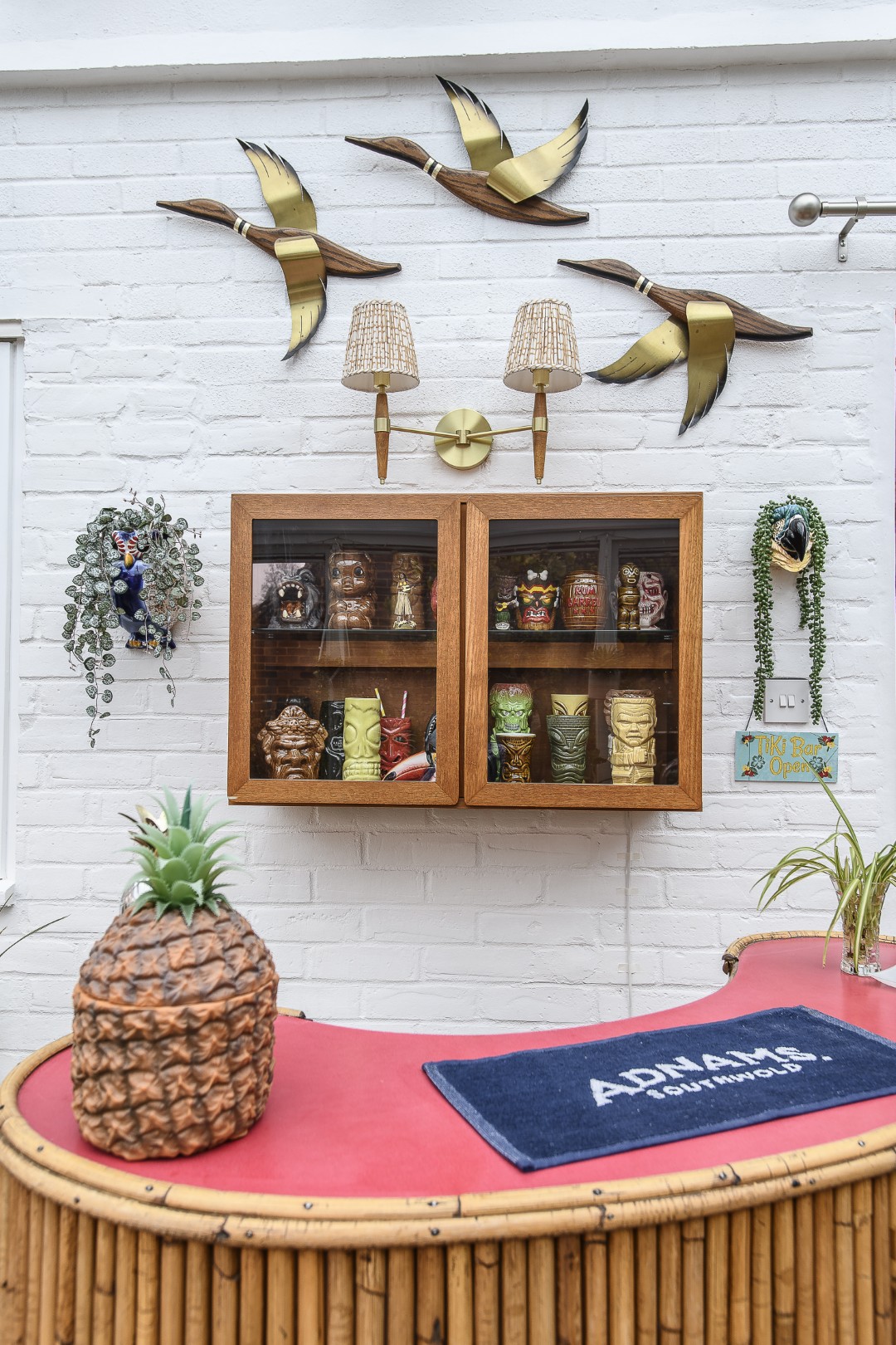 Katherine’s husband’s collection of Tiki mugs are neatly arranged behind the vintage bamboo bar that Katherine sourced locally and restored.