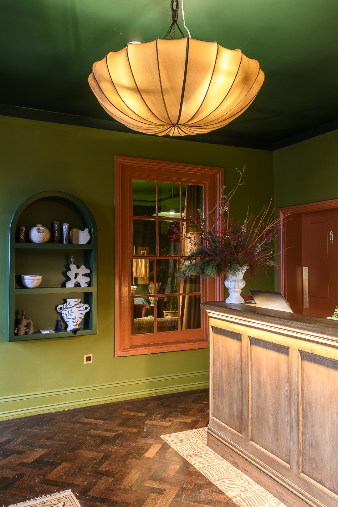 The entrance hall and reception desk, with an alcove showcasing some of the ceramics created by local artists