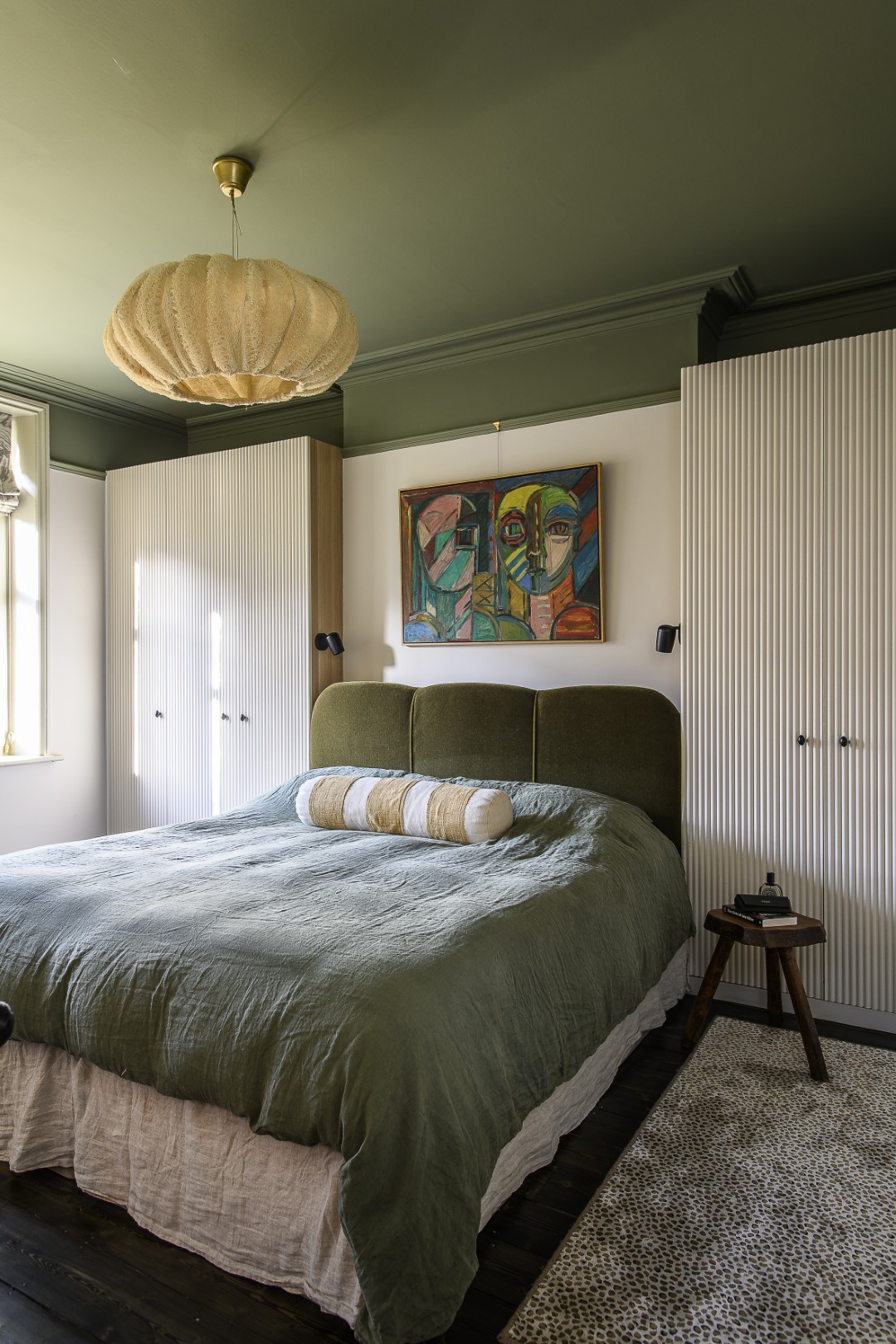 A bespoke upholstered headboard, in a rich green cotton velvet from Yarn Collective, anchors the principal bedroom, flanked by custom-made ribbed wardrobes crafted by a local joiner