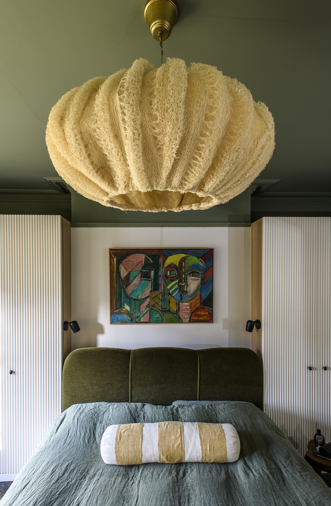 A sea urchin-shaped lampshade, made from loofahs, makes an interesting focal point above the bed