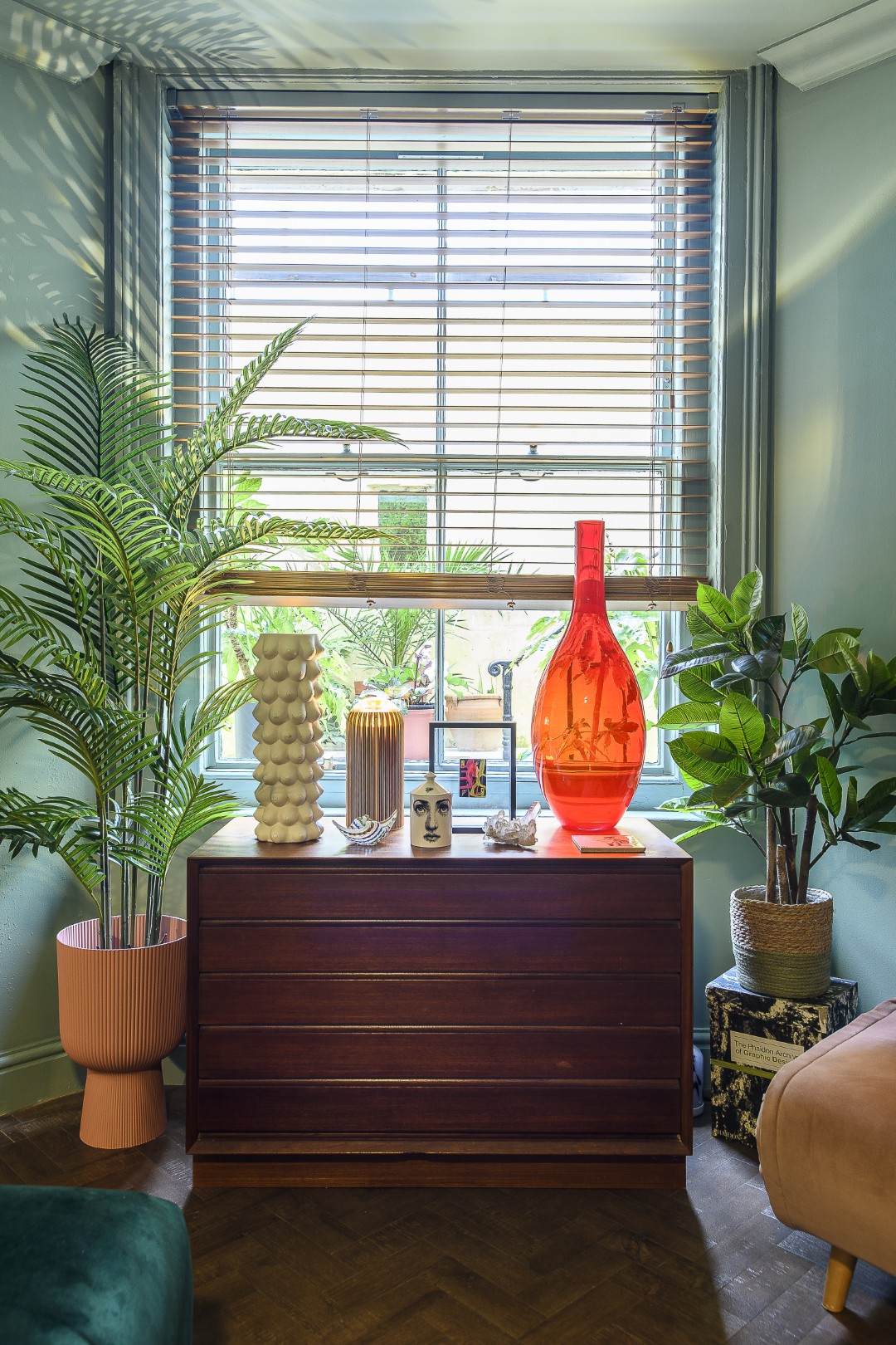  Artwork and glassware mingle with pieces by Jonathan Adler on a chest by the sitting room window  