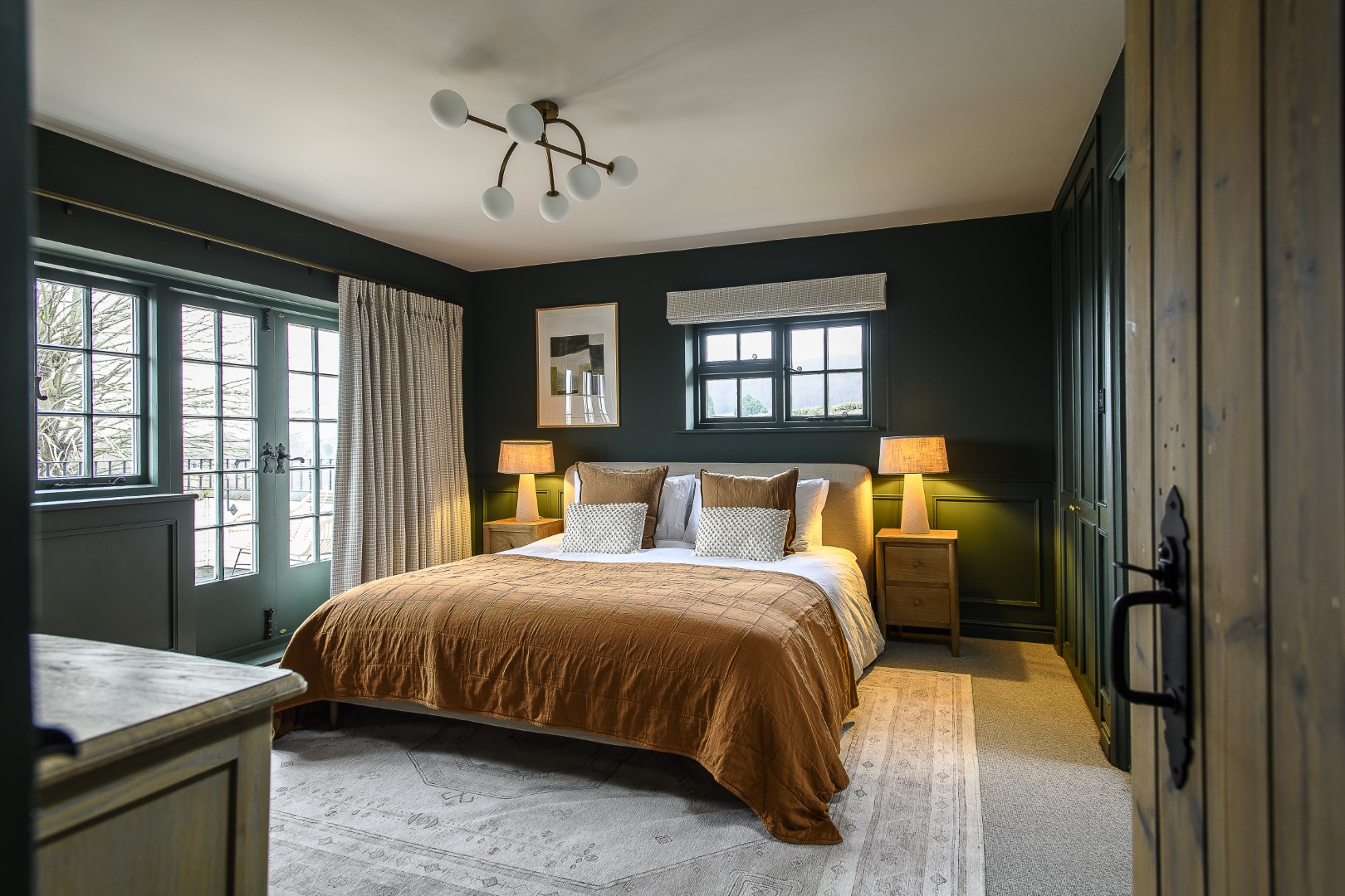 The cosy and private primary bedroom opens out onto a balcony that overlooks the orchards beyond