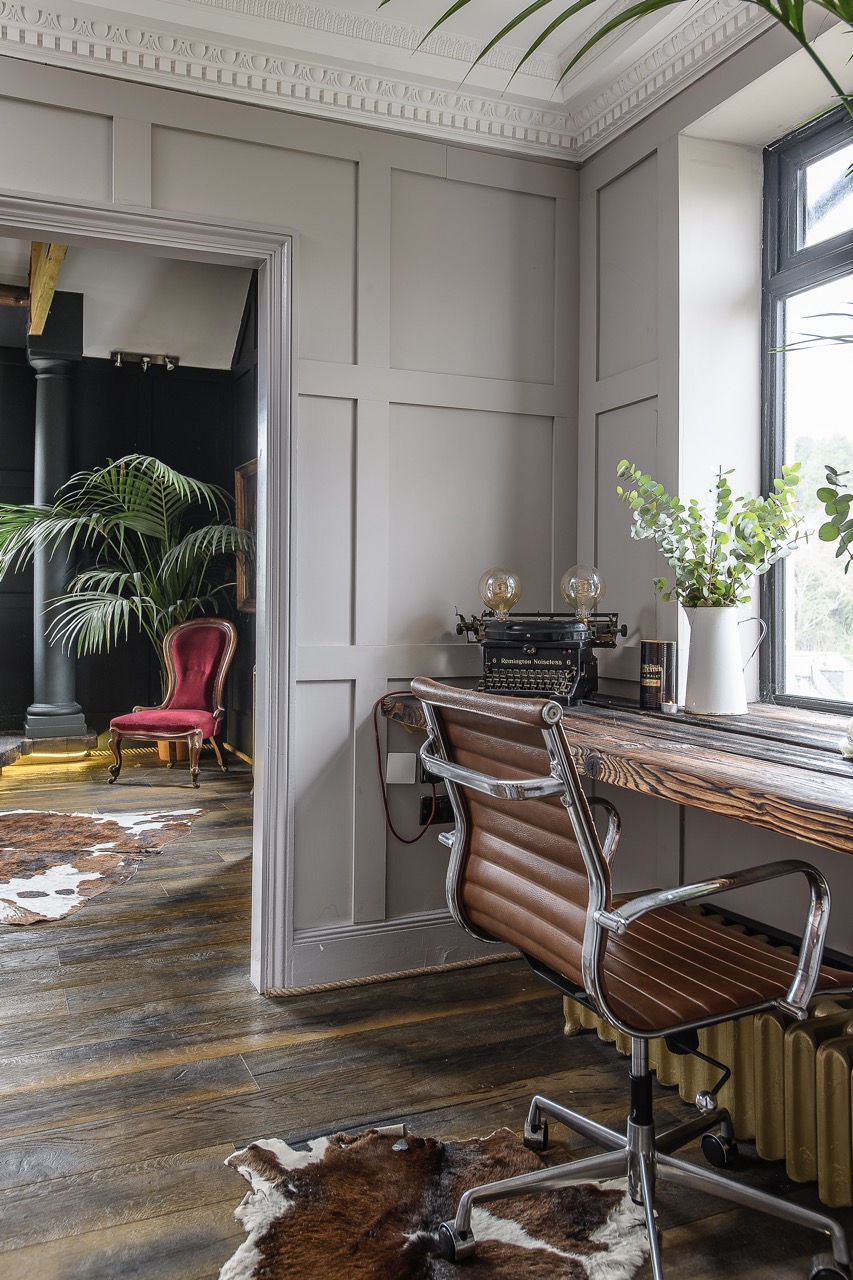 A desk tucks neatly into a space by the window on the landing.