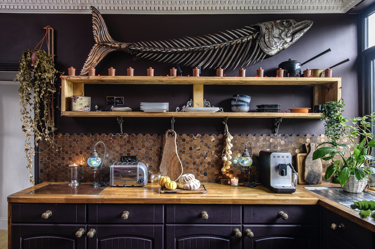 In the kitchen, scaffold boards have become open shelving. Above the wooden worktop sits a huge metal fish sculpture made by local artist Leigh Dyer.