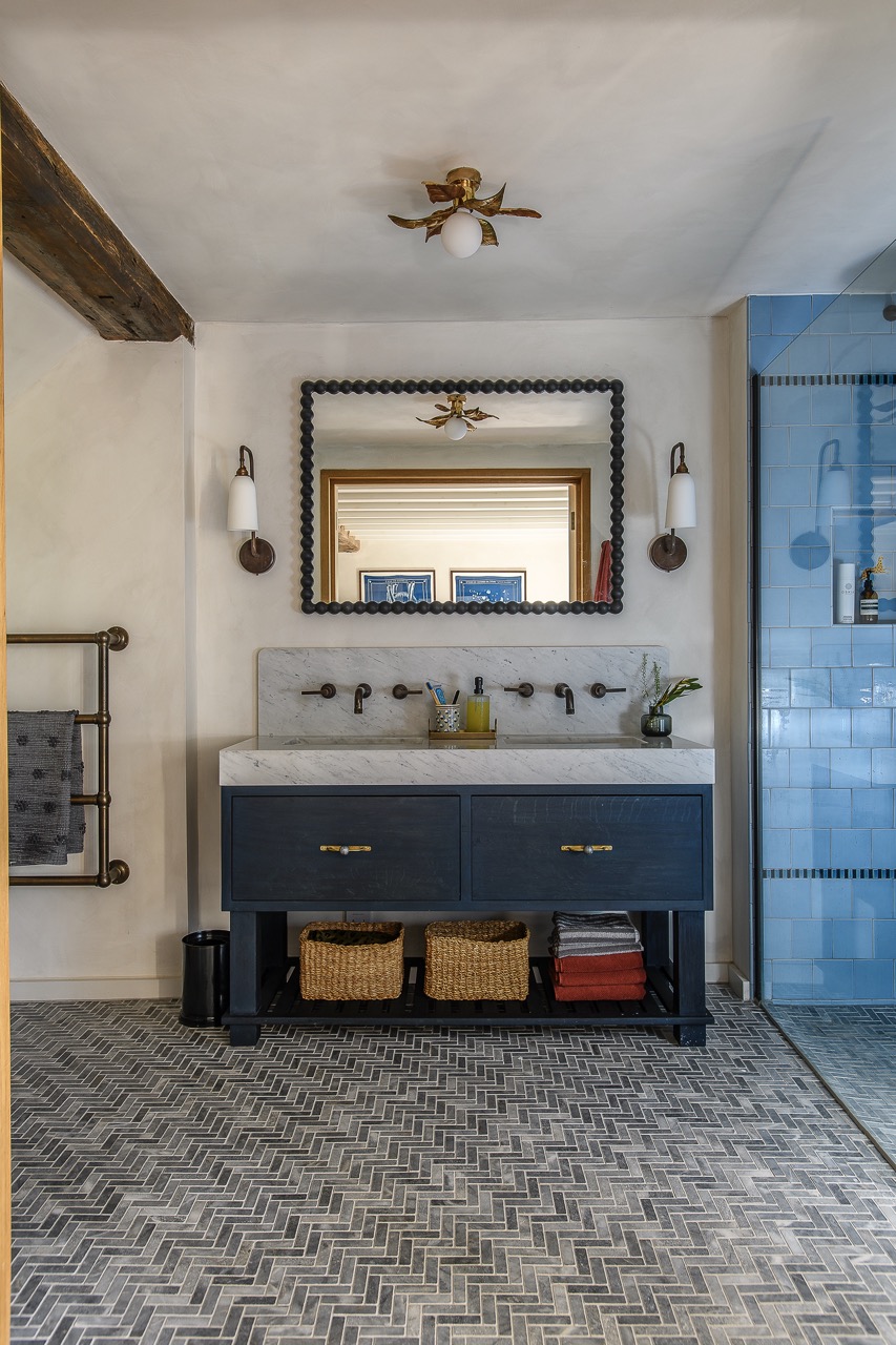 Reeded glass doors fold open to reveal a spacious en suite bathroom.