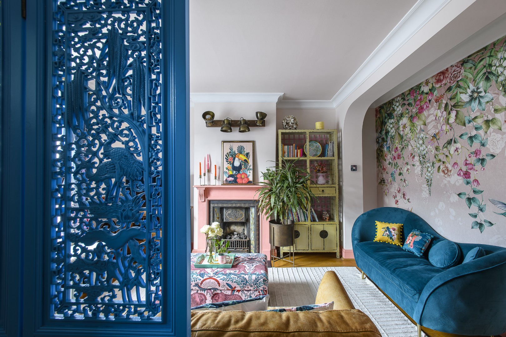 A carved wooden screen obscures the entrance hall and front door from view A bespoke mural from Graham & Brown spans the wall that divides the sitting room from the new utility area.
