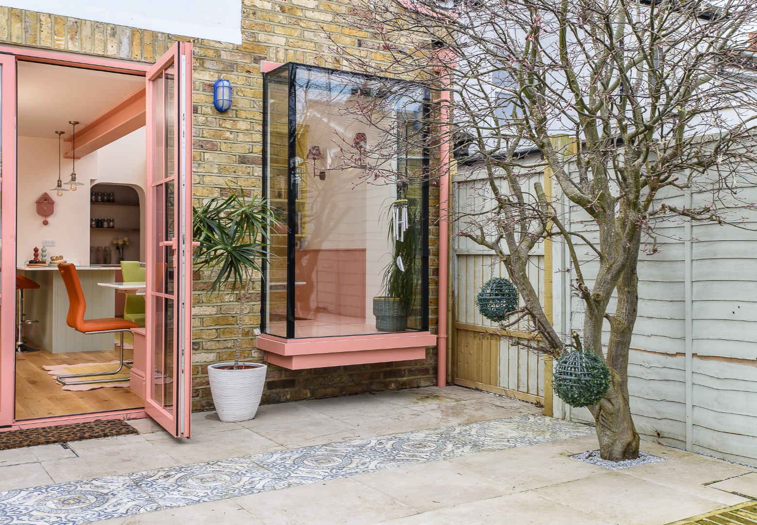 The outside is connected to the interior year-round thanks to an oriel window, installed by local contractor Luke Garrard, from PLG Construction based in Surbiton, who also made the built-in seating in the dining area