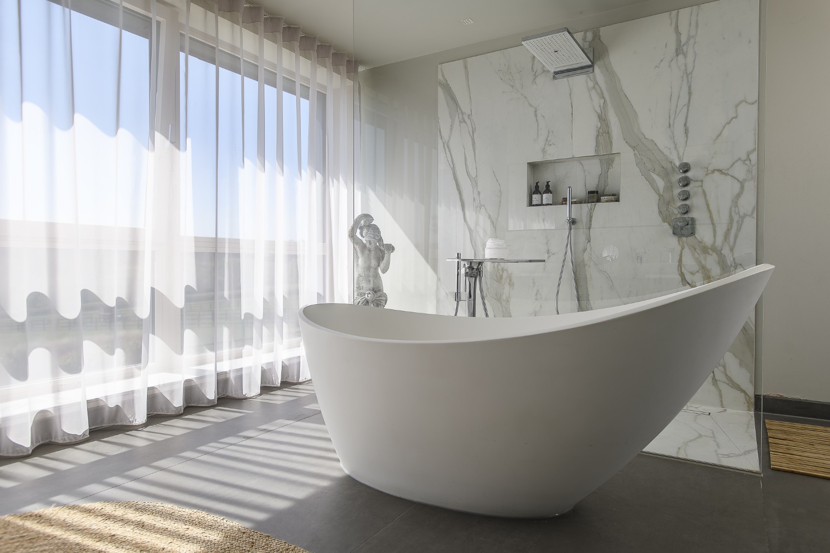 Here, an Elter freestanding bath takes prime position in the principal bedroom en suite which enjoys amazing views over the garden below and the forest beyond
