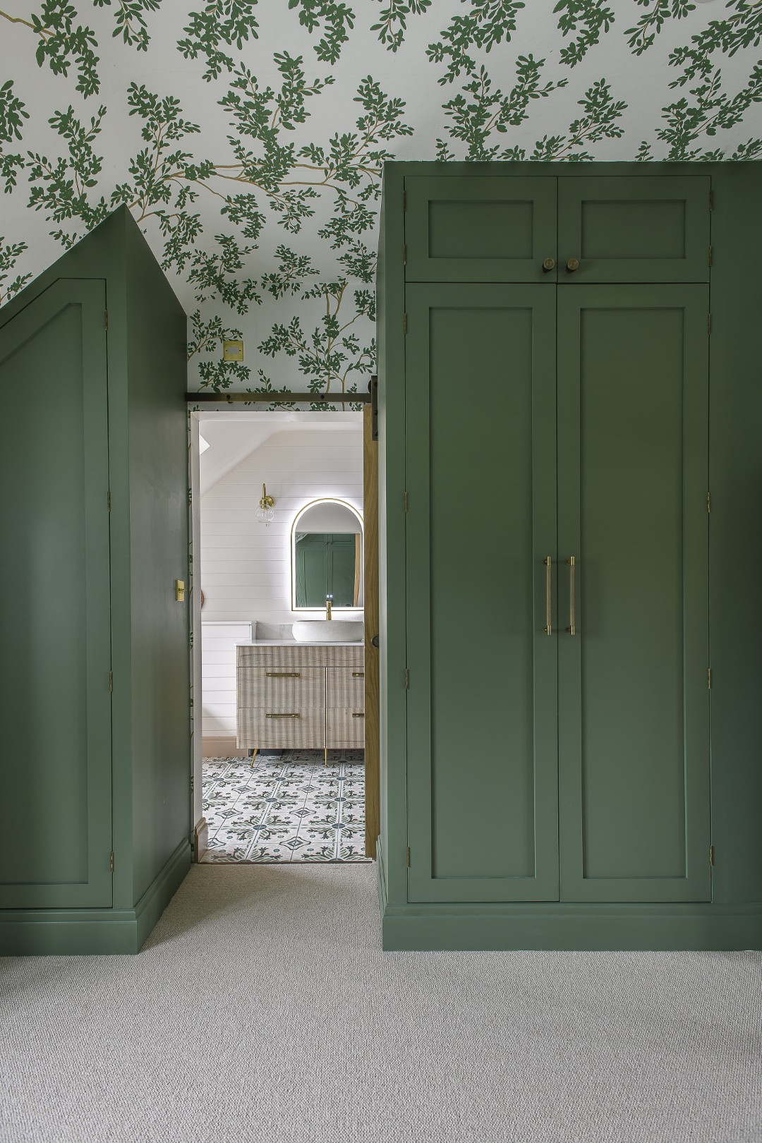 The principal bedroom’s en suite mirrors the green tones throughout.