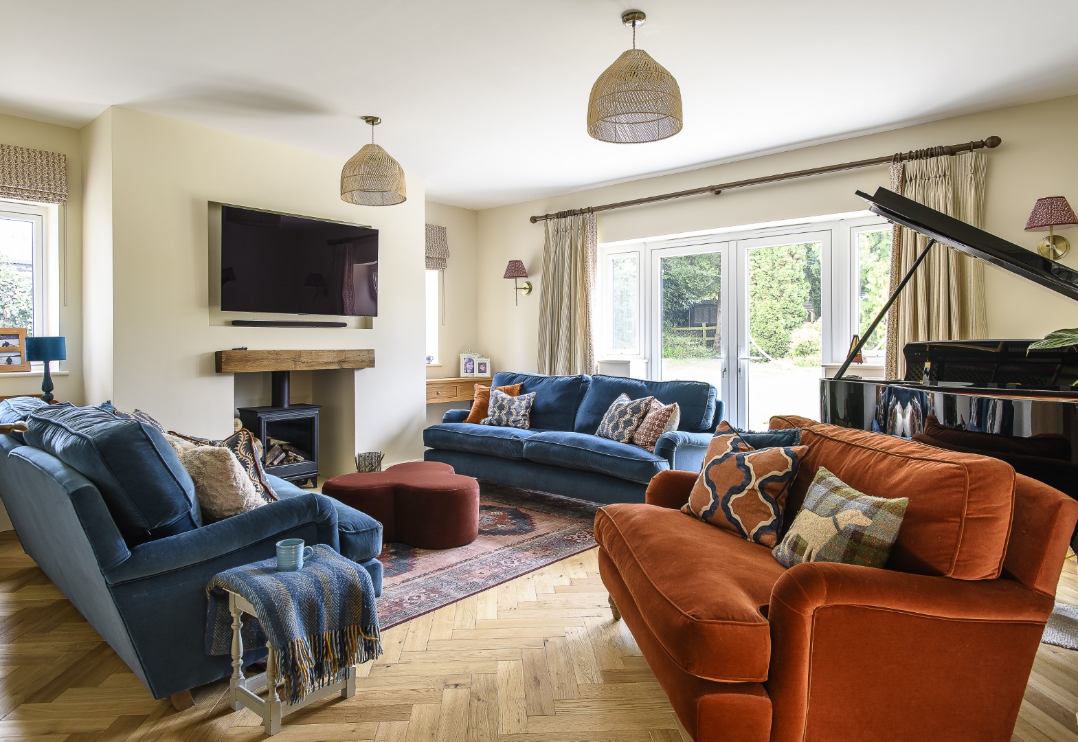 In the more formal sitting room, home to a grand piano, Jenny has combined rich velvet sofas with an upholstered coffee table from M&S