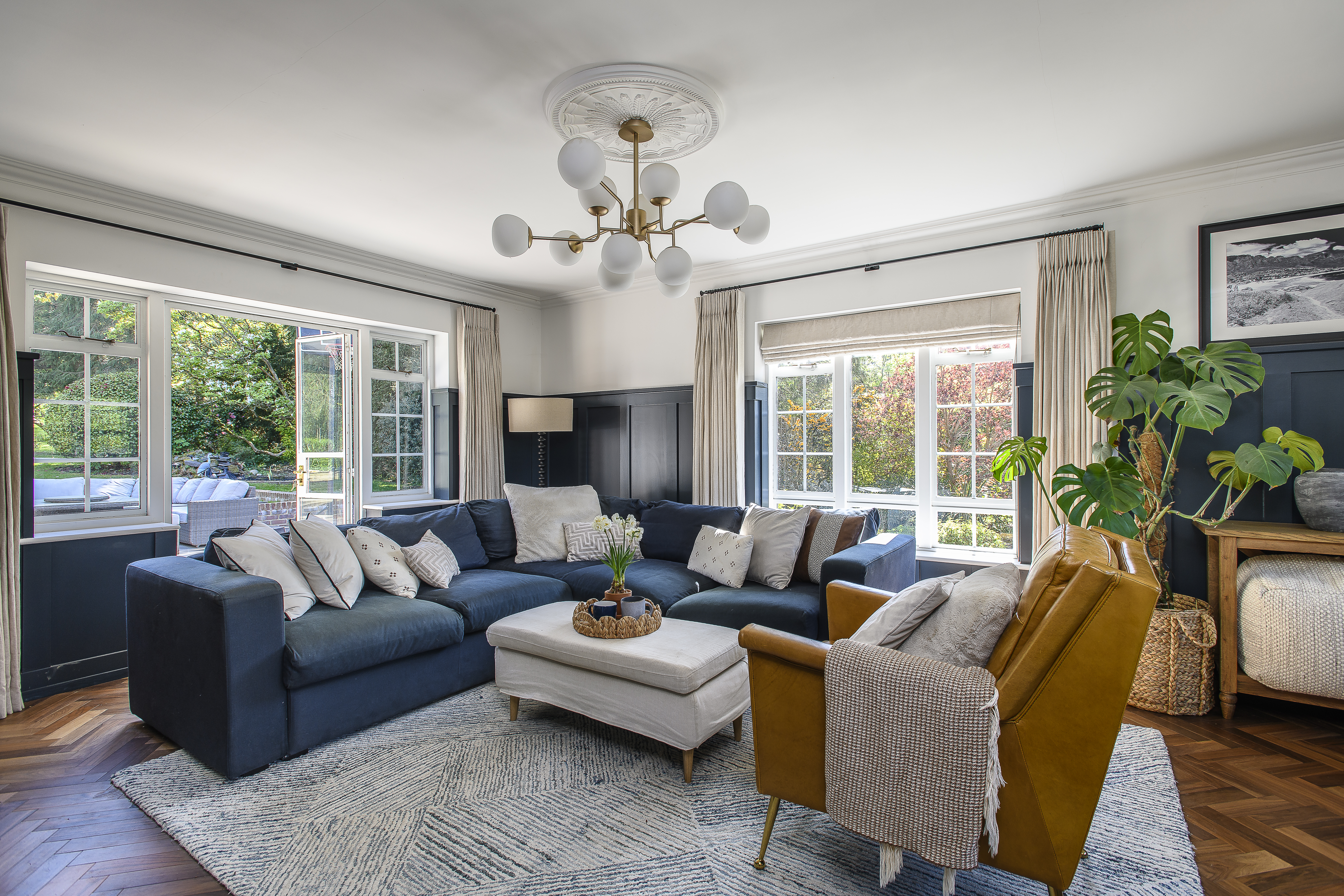 In the living room, softly patterned grey furnishings offset the deep navy sofa, bringing a contrast to the room that echoes the open-plan living space next door