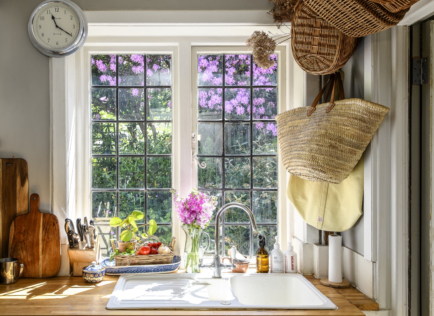 With space at a premium, Aga has been creative with storage throughout the cottage. Baskets frame the kitchen window.