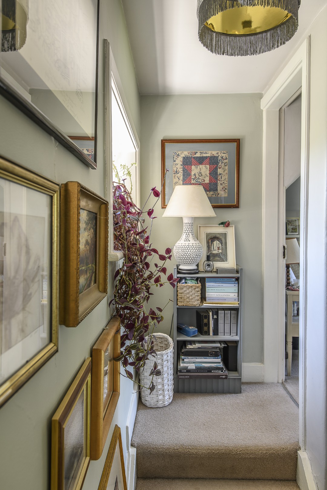 Up the staircase, lined with framed artworks.