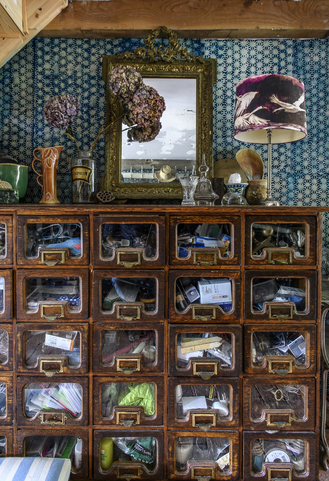 In a passage that runs underneath the stairs is a storage area, home to an old drapers unit with over thirty drawers.