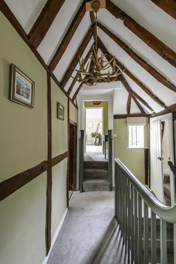 Beams Line the green hallway between each of the bedrooms