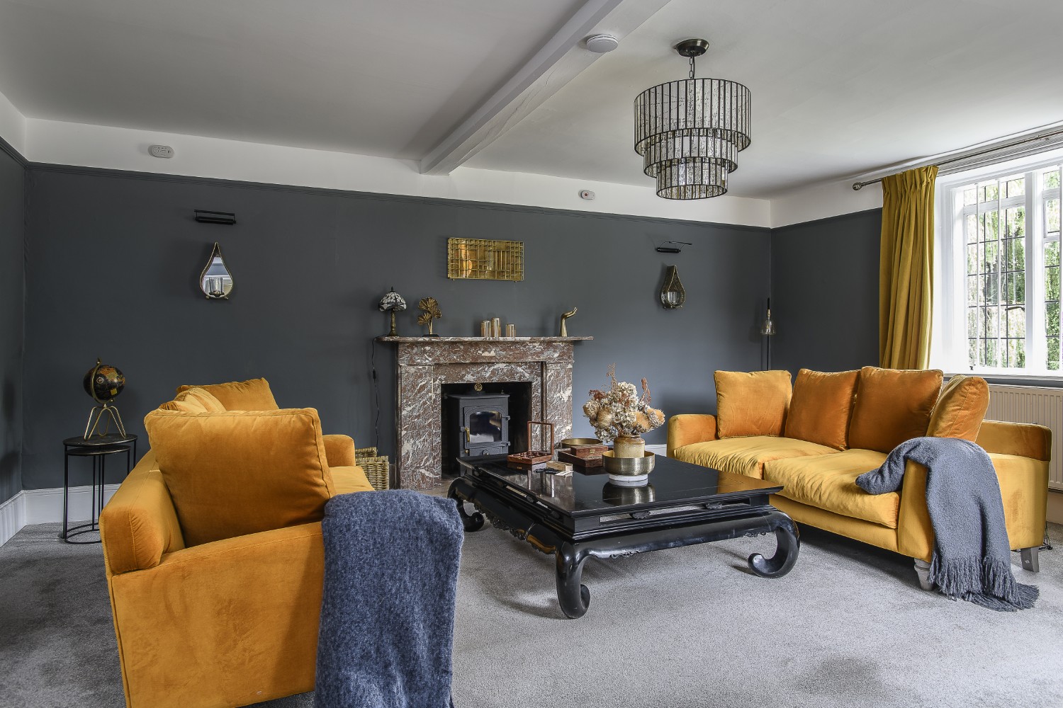 Seating in the drawing room gathers around the marble fireplace
