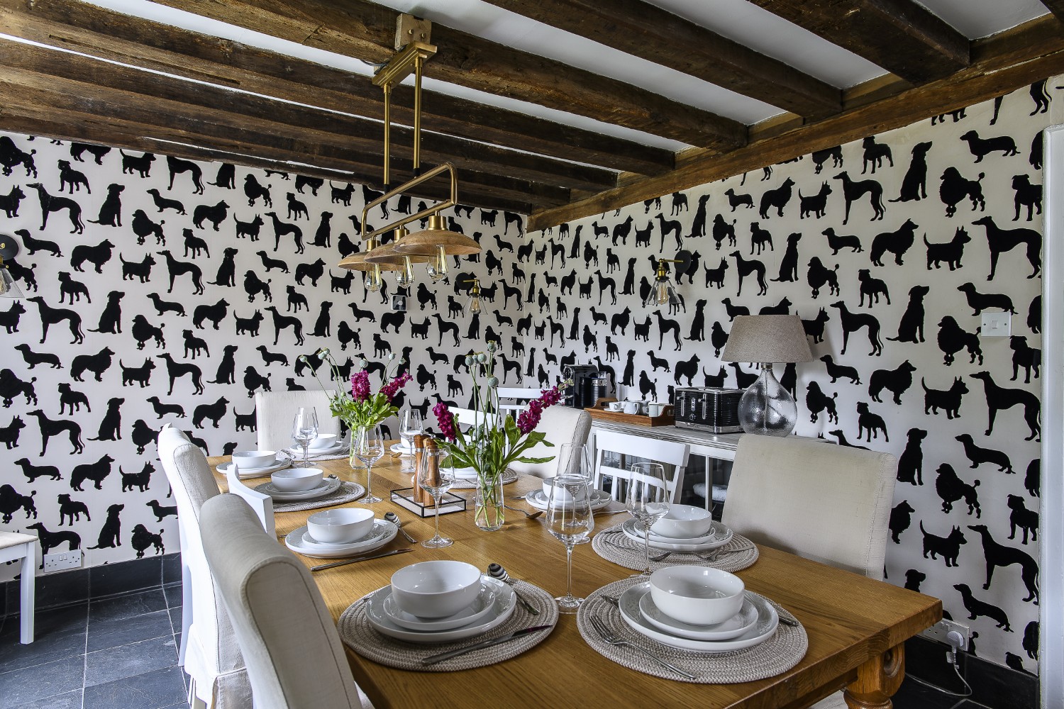 The dining room of this dog-friendly retreat is papered in Osborne & Little’s ‘Best in show’