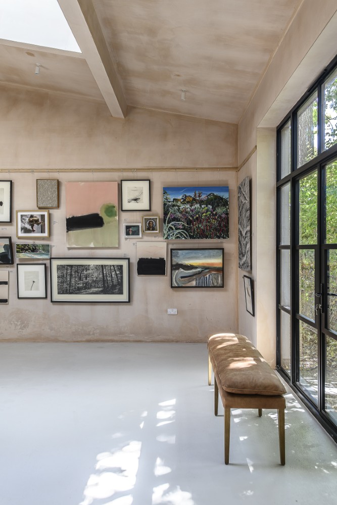 Dappled light that filters through the trees outside projects ever changing patterns across the gallery’s walls and floor