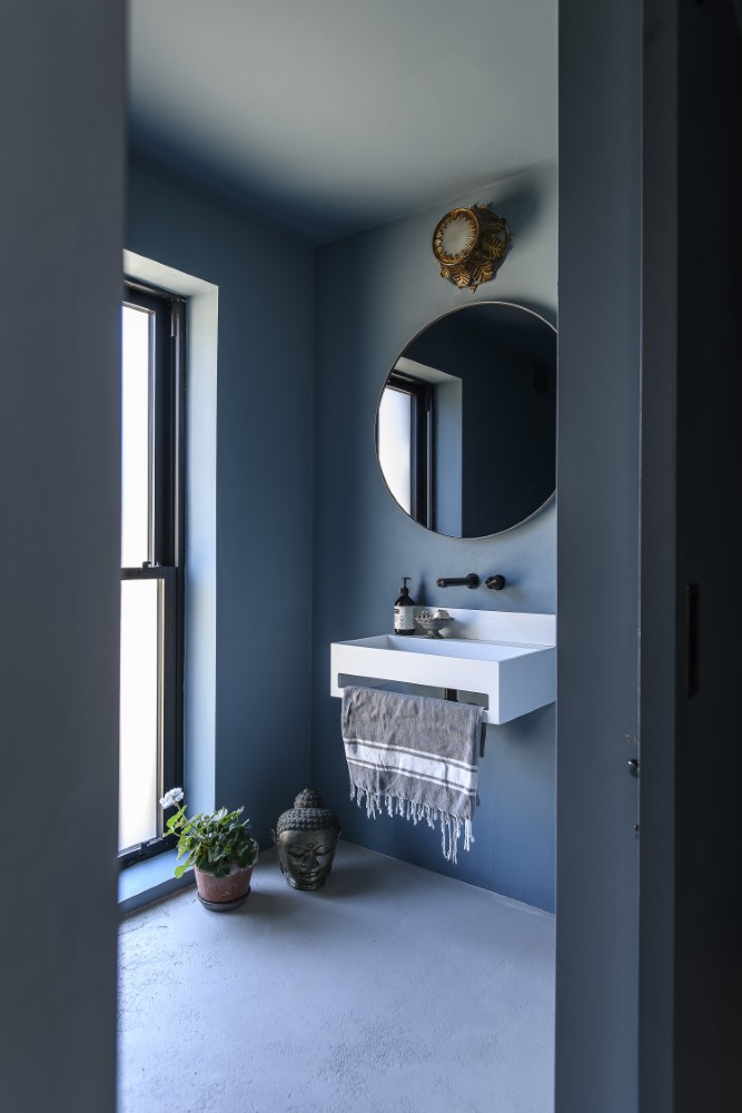Wrapped in an inky blue palette, the cloakroom feels both cocooning and refined