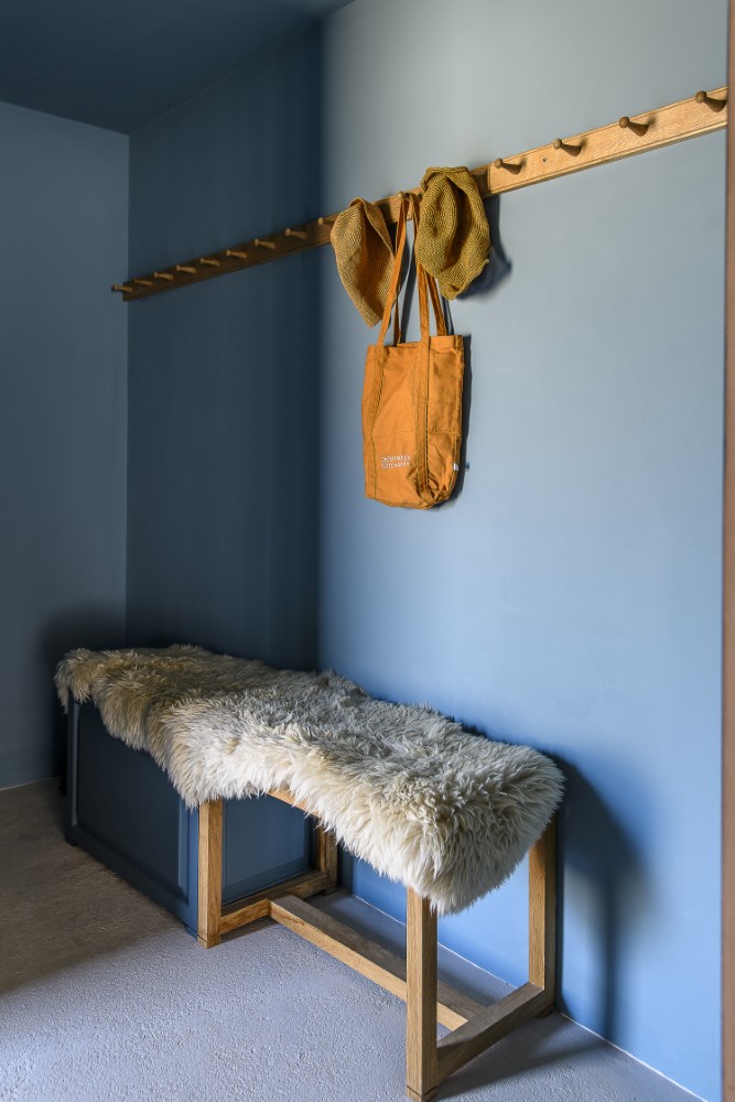 Wrapped in an inky blue palette, the cloakroom feels both cocooning and refined