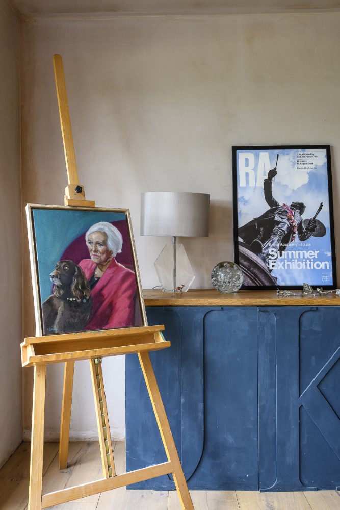 A portrait of Mary Berry by Paulina Kwietniewska (Sky Arts Portrait Artist of the Year 2025 semi-finalist) is displayed on an easel in the family’s snug, next to a monogrammed piece of furniture that Élise created in collaboration with a local joiner.