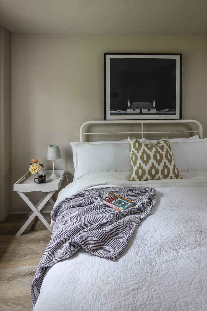 The cosy bedrooms are colour drenched, creating a cocooning feel. A print by Ron Lawson hangs above the bed