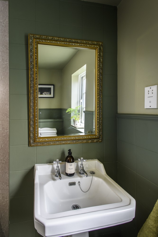 A soothing two-tone green scheme brings depth and a fresh, nature-inspired feel to the bathroom